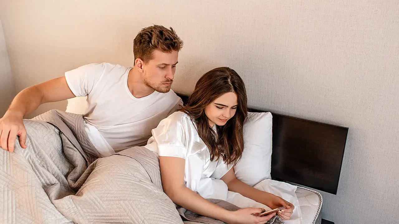A man looking at his girlfriends phone A man looking at his girlfriends phone